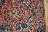 Vintage Farahan Sarouk rug detail: coral field, intricate blossoms, palmettes, and navy border.