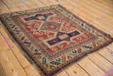 Antique Kazak rug border detail, showing cherry red, navy blue Avar cartouches and aged texture.