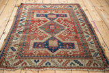 Antique Kazak rug edge showcasing textured pile, navy, cherry red Avar cartouches.