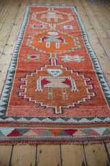 Distressed rust and orange human figure motif with stepped contour on vintage Kurd runner.