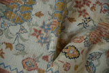 Distressed vintage Oushak rug detail, showing floral bouquets, chevron pattern, and soft pile wear.