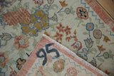 Folded corner of distressed Oushak rug revealing painted 
