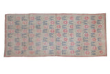 Distressed vintage Oushak runner with raspberry starbursts and teal vines on a platinum field.