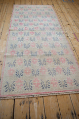 Angled view down the full length of the distressed Oushak runner, showing its repeating pattern.