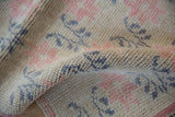 Close detail of the distressed Oushak runner's pile, showing even wear to the knot heads.