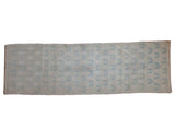 Distressed vintage Oushak runner with faded platinum, pale blue, and dusty rose floral vine motifs.