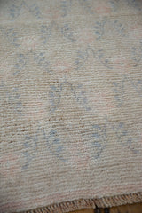 Short, distressed pile of the Oushak runner, with faded blue and rose patterns.