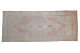 Distressed Oushak runner with double concentric medallions in faded pink, sand, and mint green.