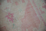 Detail of the distressed low pile with bubblegum pink and faded mint green blossoms.