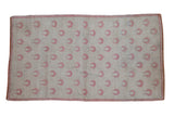 Distressed vintage Oushak rug with rows of raspberry rose tulip motifs across a soft ivory field.