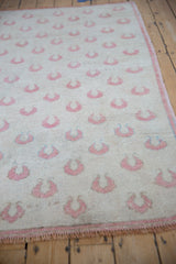 Close-up on the even, low-pile wear of the vintage Oushak's rose tulip pattern.