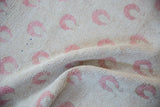 Worn pile and hand-knotted texture of a vintage Oushak rug with blush pink tulip blossoms.