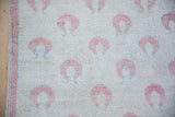 Evenly worn, low-pile texture of a vintage Oushak with dusty rose and powder blue motifs.