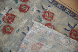 Vintage distressed Oushak rug corner, revealing hand-knotted foundation and worn rose bouquets.