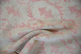 A close-up view of a vintage Oushak rug shows its pliable texture and even, low pile.