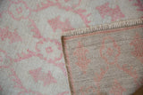 A folded corner of the vintage Oushak runner reveals its hand-knotted back and worn pile.