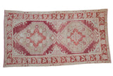 Vintage distressed Oushak carpet with stepped double medallions in faded cochineal red and ivory.