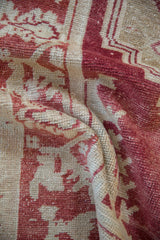 Evenly worn hand-knotted texture of a vintage Oushak rug in cochineal red and soft ivory.