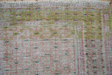 Distressed Oushak rug section showing worn texture, knot heads, and pale cochineal and lime colors.