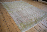 Distressed Oushak rug pile with subtle trellis pattern, faded cochineal, lime green hues.