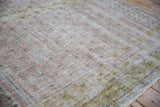 Distressed Oushak rug with mottled pale cochineal and lime green hues, showing foundation wear.