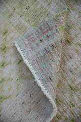 Vintage distressed Oushak rug corner revealing foundation, pale cochineal, lime green pile, and wear.