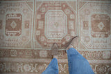 Muted coffee brown, pale blue, and blush geometric patterns with a distressed low pile.