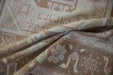 Low pile texture with coffee brown, ivory, and blush stylized gul motifs.