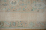 Distressed pile texture of vintage Oushak carpet border with cream and mint motifs.