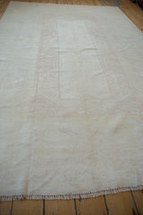 Distressed Dosemealti carpet with faint geometric pattern, weaver delimiters, and fringe.