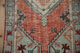 Textured brick red abrashed field with visible wear to knot heads on vintage Oushak runner.