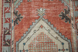 Distressed brick red field, beige spandrel, and slate blue border on vintage Oushak runner.