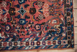 Distinct barber pole and floral borders on a Persian Borchalou rug, brick red and sapphire blue.
