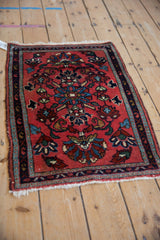 Vintage Lilihan Persian rug mat seen from an angle, showing its floral medallion and deep blush field.