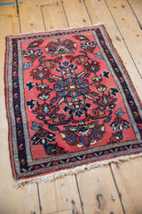 Angled view of a traditional Persian Lilihan rug mat with a blush field and navy blue floral patterns.