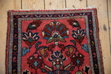 Corner view of the vintage Lilihan rug's navy blue boteh seed border and side cord selvage.