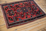 Angled view of a vintage Lilihan rug with a meandering vine border and blush floral field.