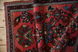 Folded corner of a vintage Lilihan rug showing its plush pile and floral vine border.