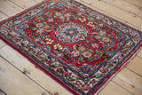 Secured side cords and characterful tattered ends on a vintage Persian Qazvin floral rug mat.