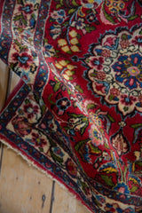 A vintage Persian Qazvin rug's plush texture and detailed rose and meandering vine border.