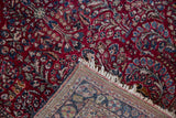 Folded corner of a vintage Sarouk rug revealing its dense hand-knotted back and floral pile.