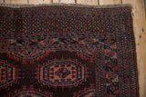 Vintage Turkmen rug corner with dark brown, pale red geometric and checkered outer borders and fringe.