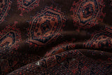 Folded vintage Turkmen rug with nuanced relief, dark chocolate field, copper, and navy gul motifs.