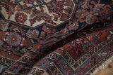 Folded vintage Bibikabad rug showing intricate Herati patterns with scrolled leaves in navy, red, and ivory.