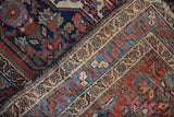 Close-up of the vintage Bibikabad rug's navy field and patterned ivory border, showing wear.