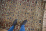 Antique Caucasian rug's saffron yellow field with terracotta, blue floral pattern, visible pile wear.