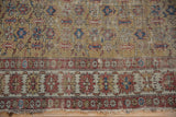 Tattered edge of antique Caucasian rug, saffron yellow field and terracotta geometric borders.