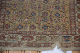 Antique Caucasian rug bottom corner, aged wear, split edge, and original macrame with ochre and terracotta patterns.