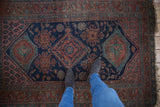 Vintage Kurdish Hamadan rug with navy medallion, madder red palmettes, and mostly even wear.
