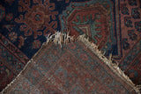 Vintage Hamadan rug's worn navy and madder pile, tattered fringe, and woven foundation.